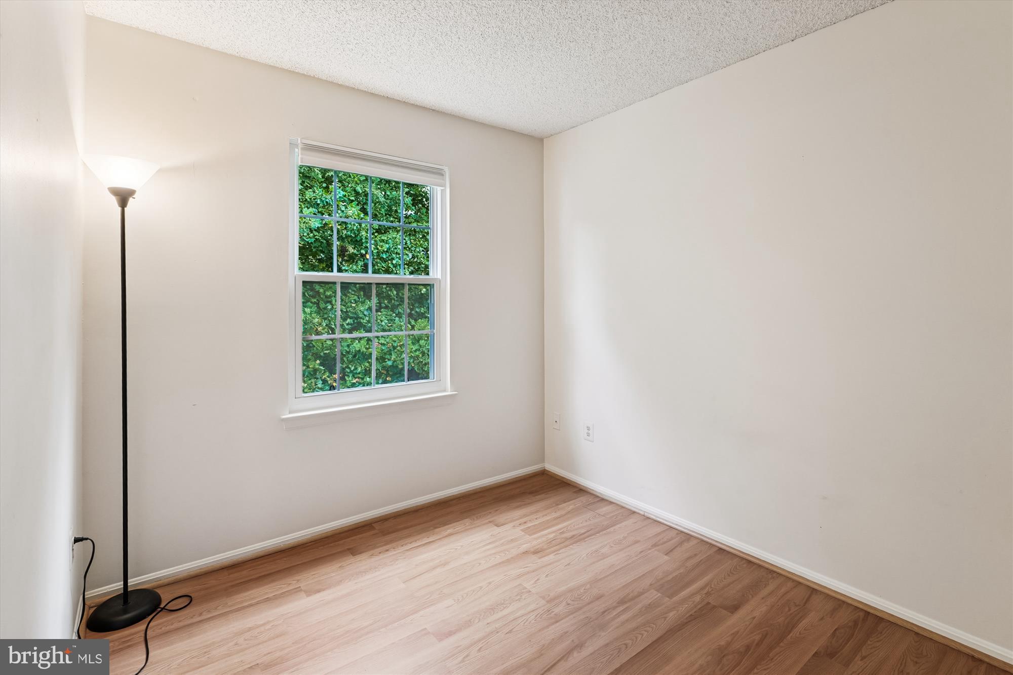 12129 Chaucer Lane, Unit 12129 Woodbridge, VA 22192 - Photo 12 of 31 a view of an empty room with wooden floor and a window