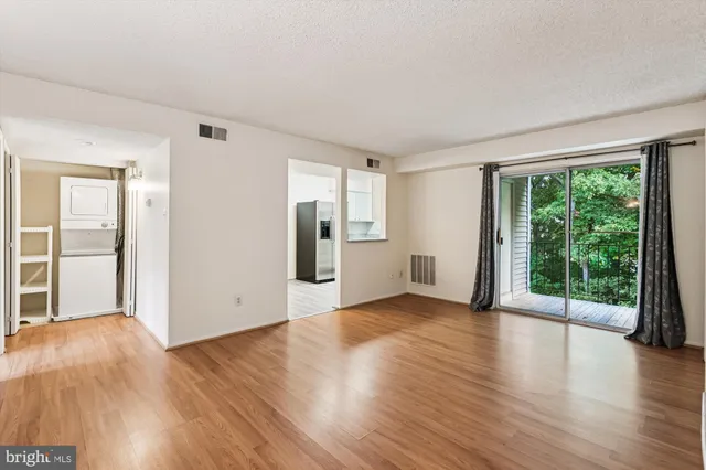 a view of a big room with wooden floor and windows