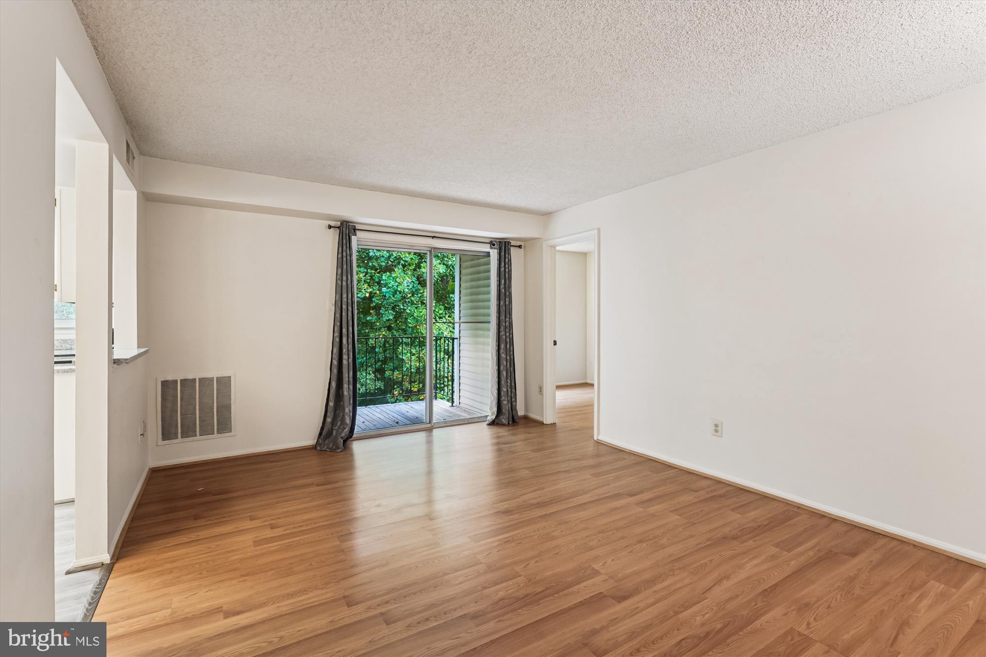 12129 Chaucer Lane, Unit 12129 Woodbridge, VA 22192 - Photo 3 of 31 a view of an empty room with wooden floor and a window