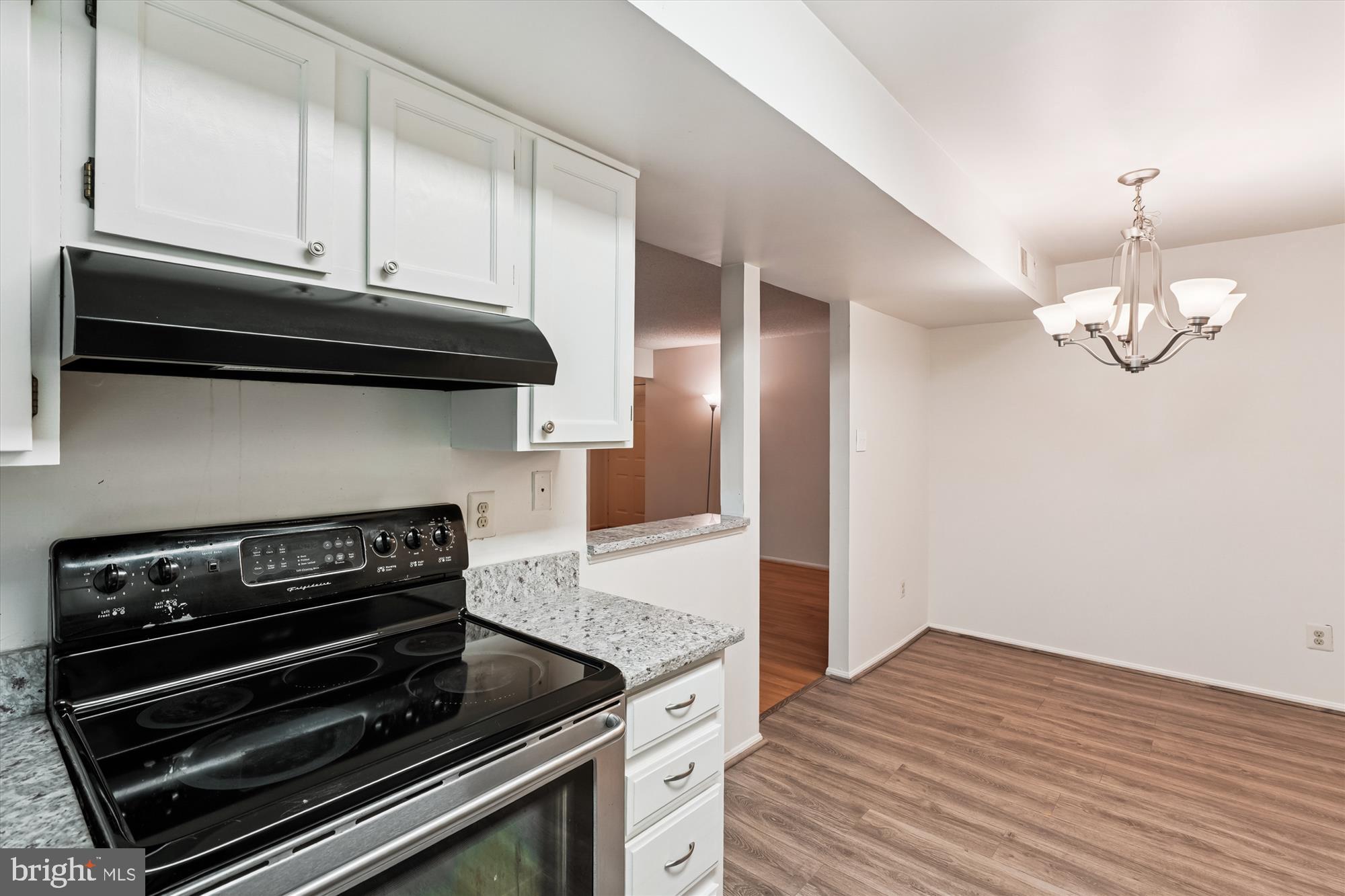 12129 Chaucer Lane, Unit 12129 Woodbridge, VA 22192 - Photo 6 of 31 a kitchen with wooden cabinets and a stove top oven