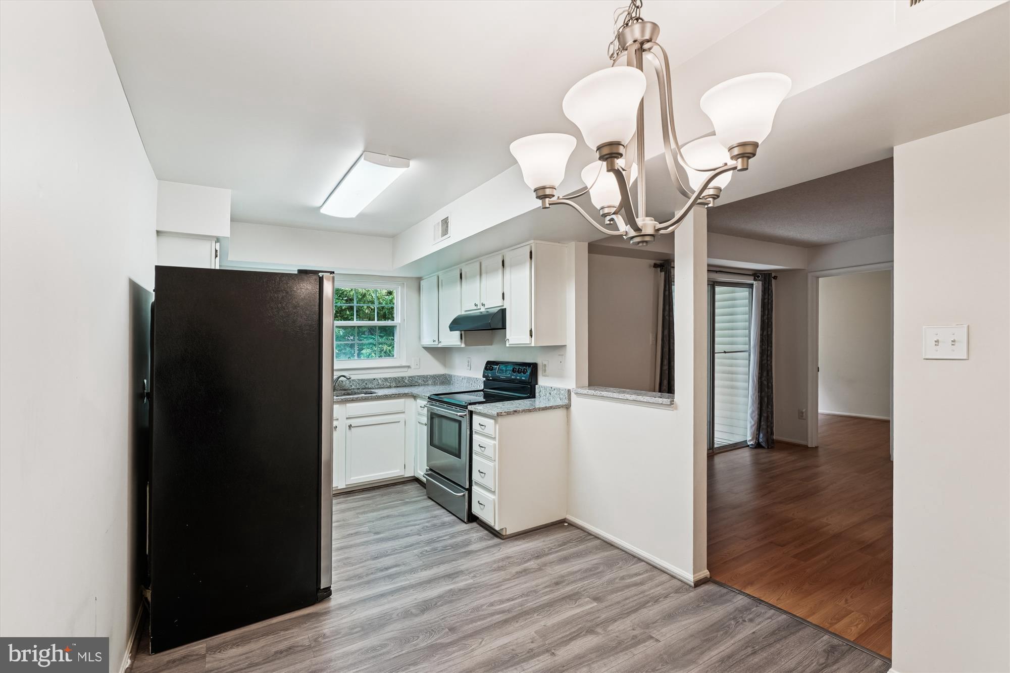 12129 Chaucer Lane, Unit 12129 Woodbridge, VA 22192 - Photo 7 of 31 a kitchen with a refrigerator a sink cabinets and wooden floor