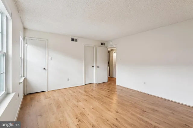 a view of an empty room with wooden floor