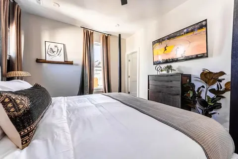 a bedroom with a bed and a flat screen tv
