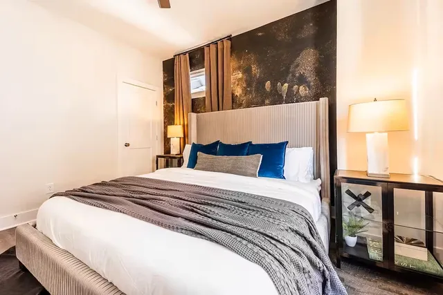 a bedroom with a bed and a painting on the wall