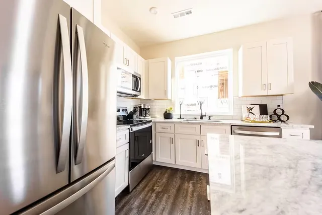 a kitchen with stainless steel appliances granite countertop a stove a sink and a refrigerator