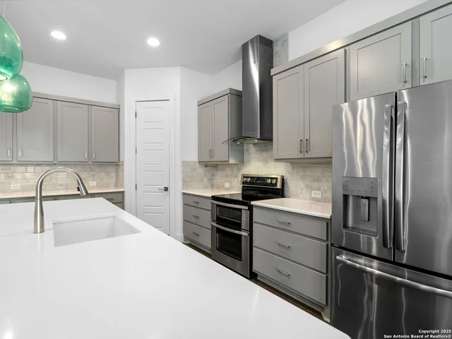 a kitchen with stainless steel appliances granite countertop a refrigerator sink and stove