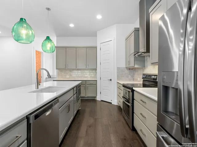 a kitchen with kitchen island granite countertop a sink stainless steel appliances and cabinets