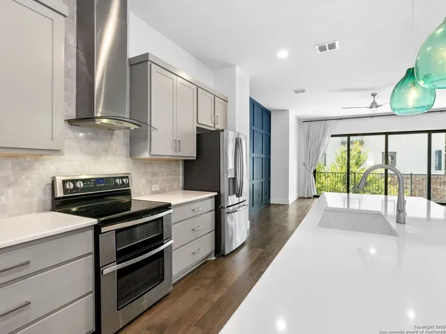 a kitchen with stainless steel appliances a stove sink and refrigerator