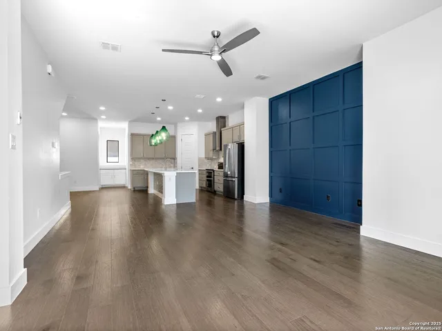 wooden floor in an empty room with a kitchen