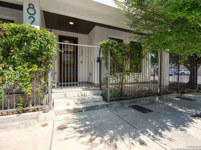 a view of a entrance gate of the house and trees