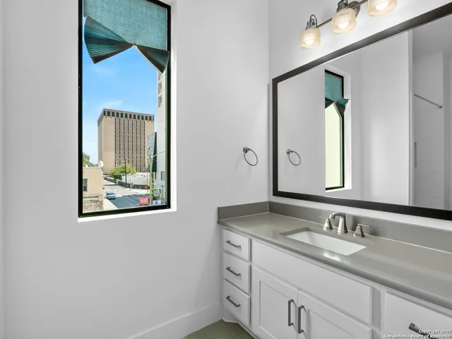 a bathroom with a granite countertop sink and a mirror