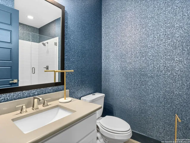 a bathroom with a sink a toilet and mirror