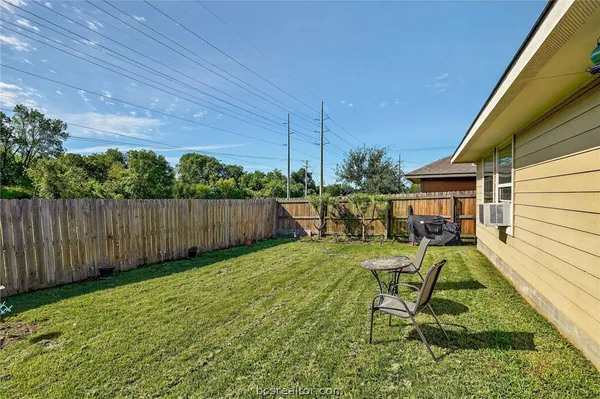 a view of a chair and table in backyard of the house