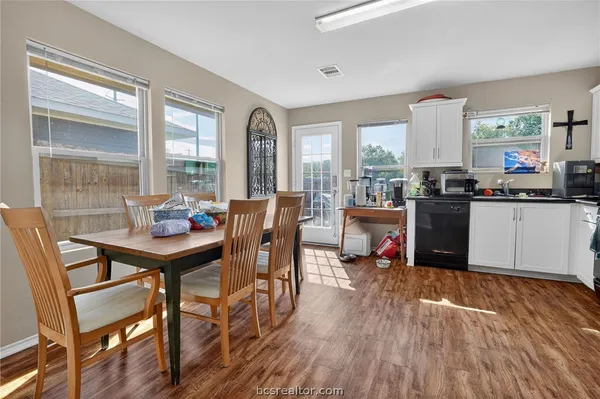 a kitchen with a table chairs stove and wooden floor