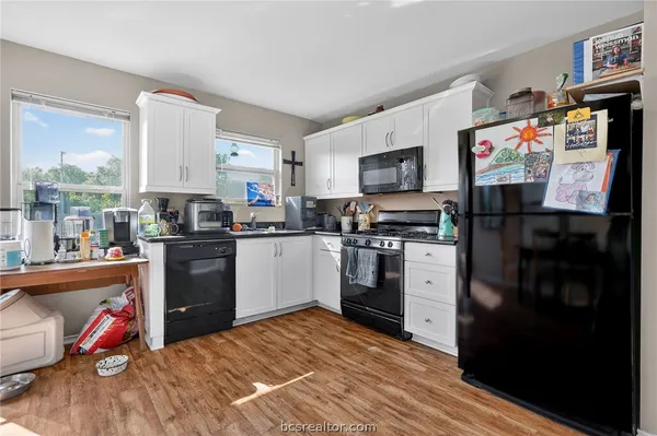 a kitchen with stainless steel appliances kitchen island granite countertop a refrigerator stove and sink