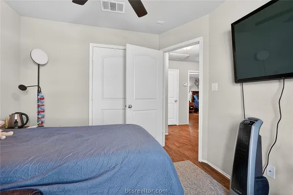 a bedroom with a bed and a flat tv screen on the dresser