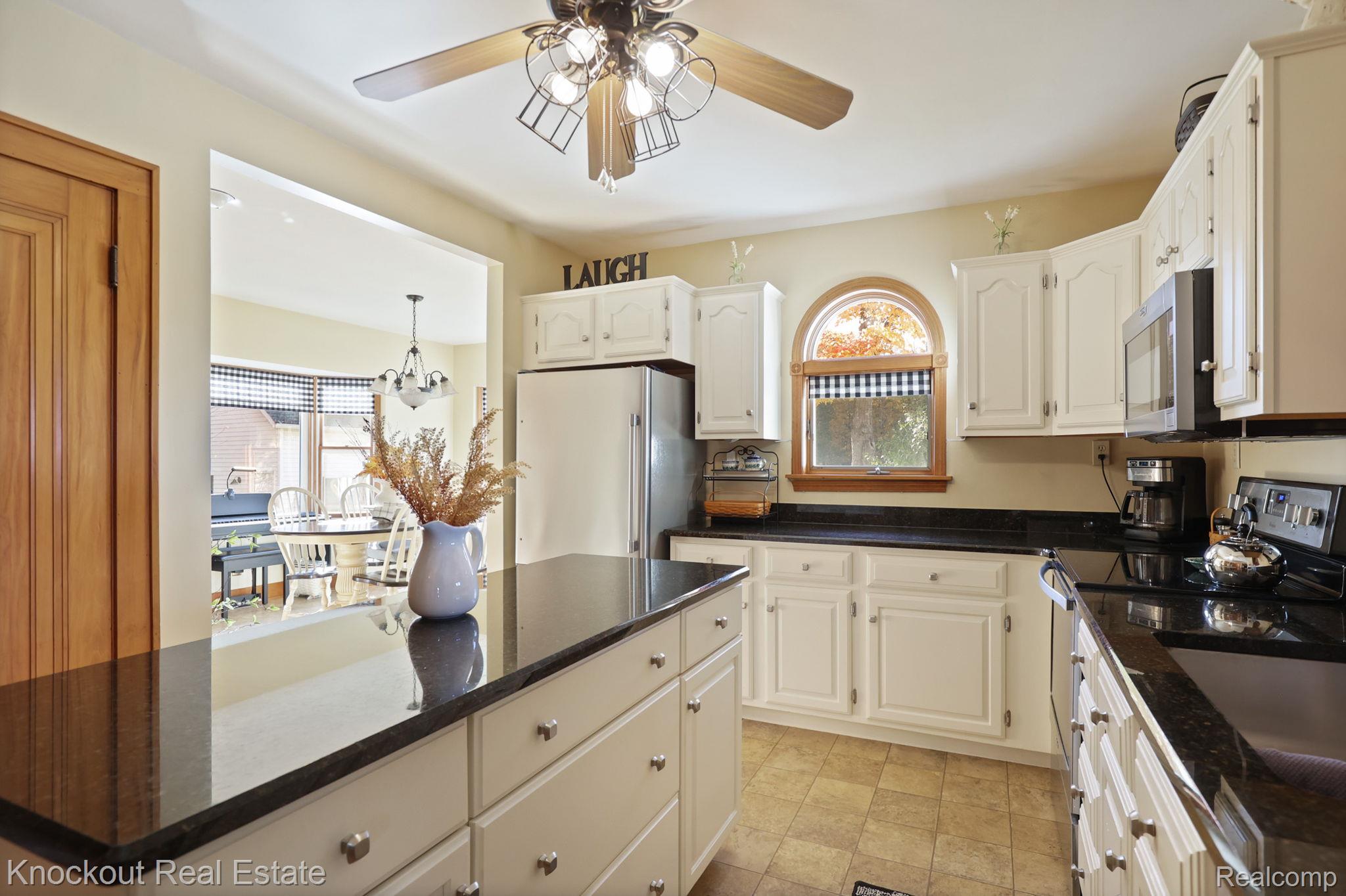 8980 Curtis Road Frankenmuth, MI 48734 - Photo 19 of 56 Kitchen with stainless steel appliances, dark stone countertops, ceiling fan, white cabinetry, and a kitchen island