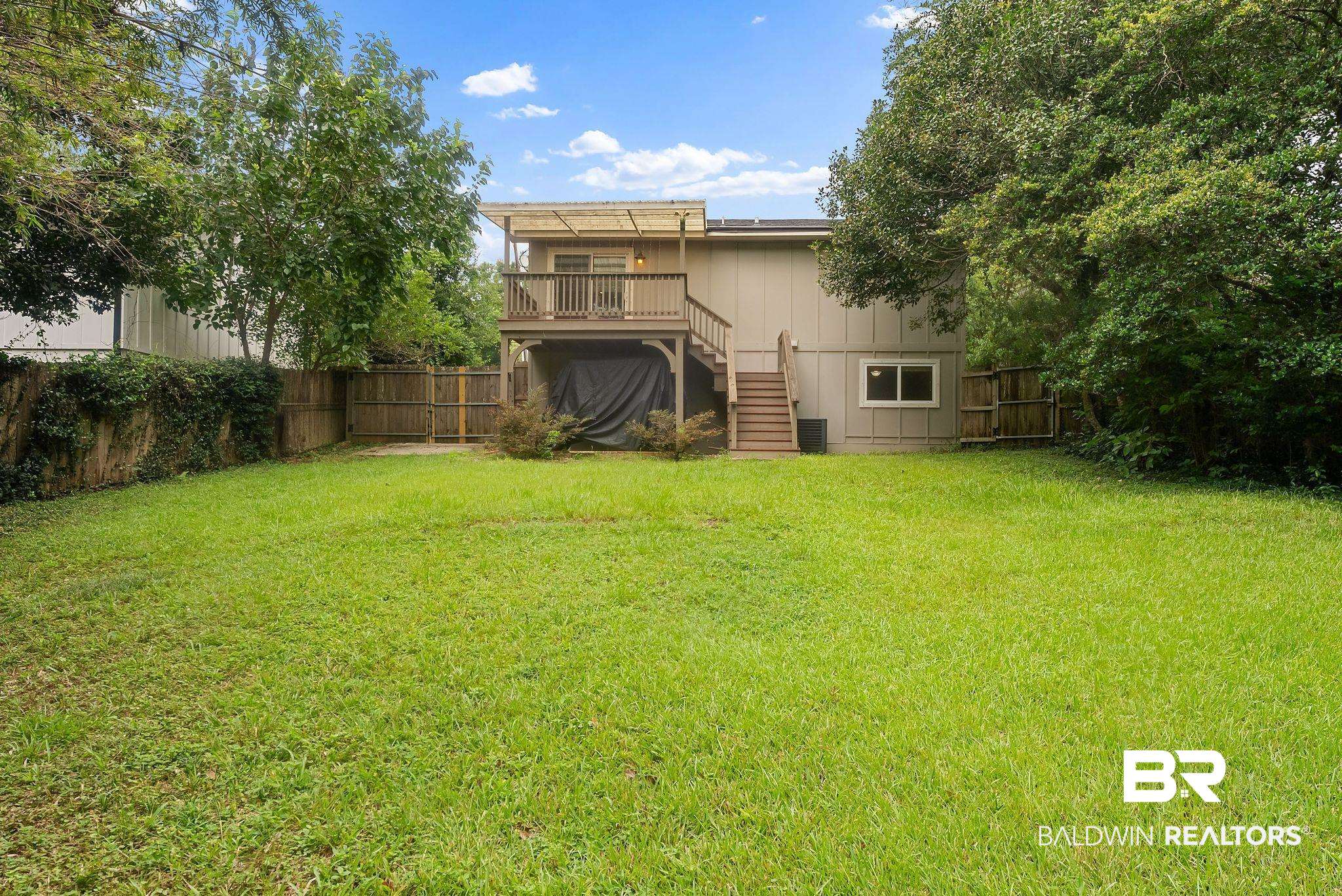 357 South School Street Fairhope, AL 36532 - Photo 36 of 44 Expansive backyard with a large grassy area, mature perimeter trees, and wood fencing