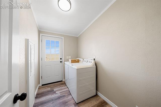 8160 Edison Road Yoder, CO 80864 - Photo 32 of 42 Washroom featuring ornamental molding, washer and dryer, and light wood-type flooring