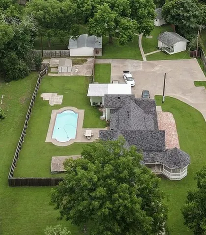 an aerial view of residential houses with outdoor space and trees