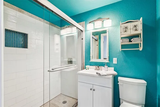 a bathroom with a sink a toilet and shower