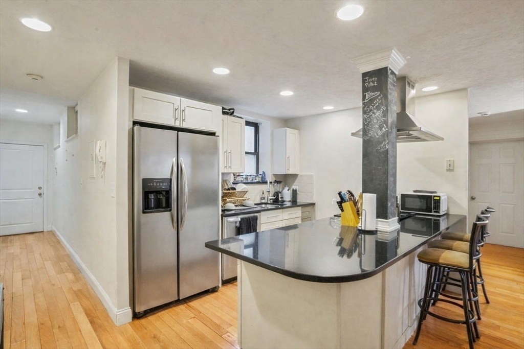 841 Parker Street, Unit 101 Boston, MA 02120 - Photo 4 of 19 a kitchen with stainless steel appliances granite countertop a sink a stove and a refrigerator