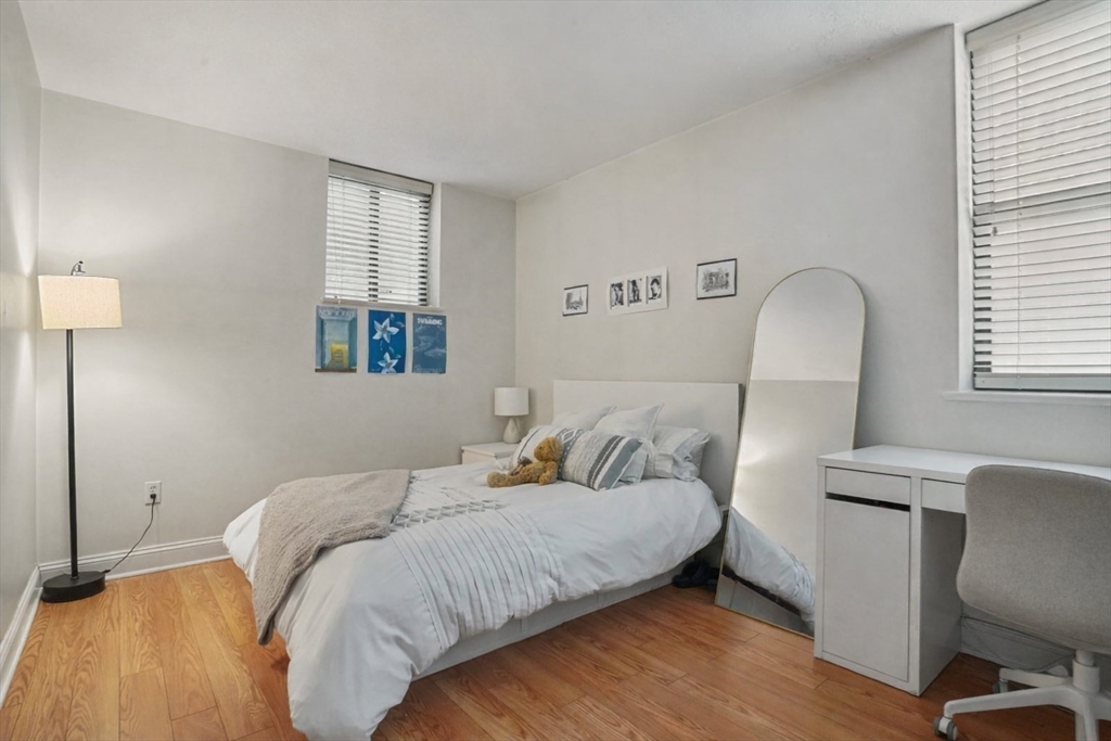 841 Parker Street, Unit 101 Boston, MA 02120 - Photo 10 of 19 a bedroom with a bed a mirror and a window