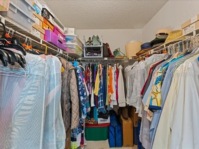 a view of walk in closet with clothes