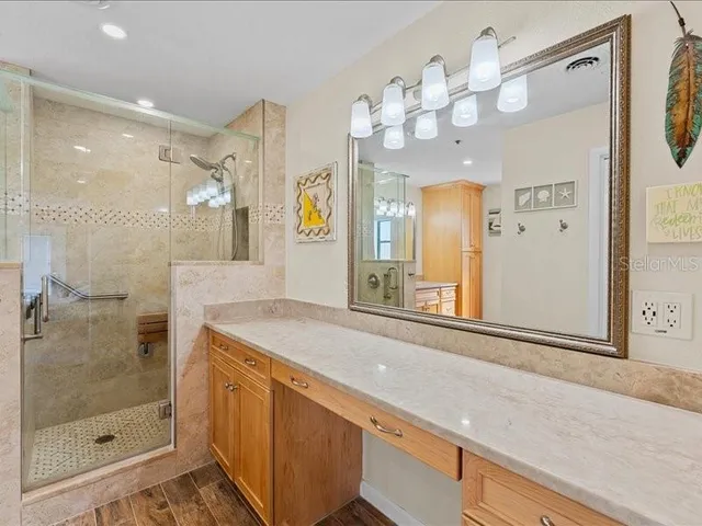 a bathroom with a granite countertop sink a mirror and a shower