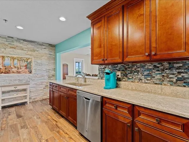 a kitchen with stainless steel appliances granite countertop a sink a stove and cabinets