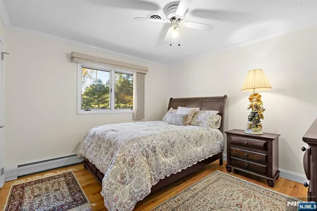 a bedroom with a bed chandelier and a window