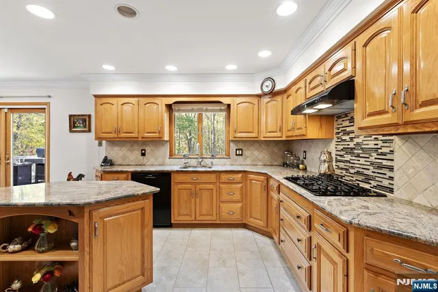 a kitchen with granite countertop a sink stove and cabinets