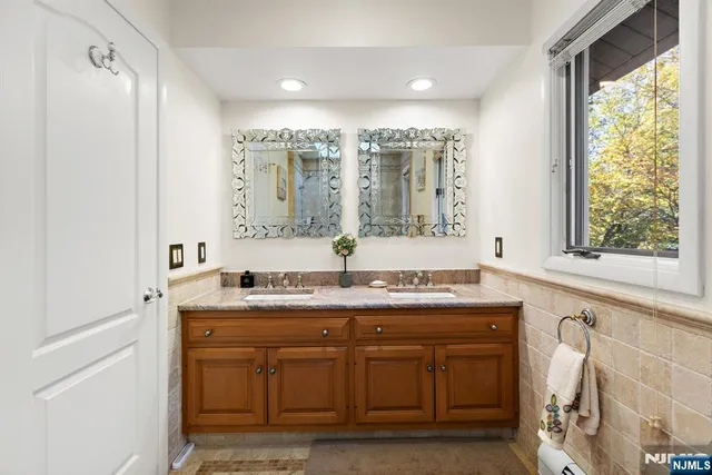 a bathroom with a granite countertop sink a mirror and a shower