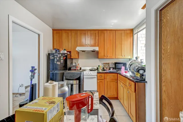a kitchen with a refrigerator and a stove top oven