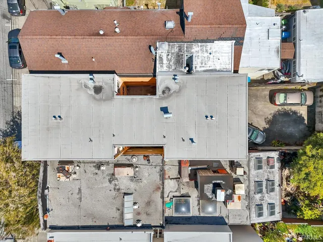 an aerial view of residential houses with outdoor space and parking