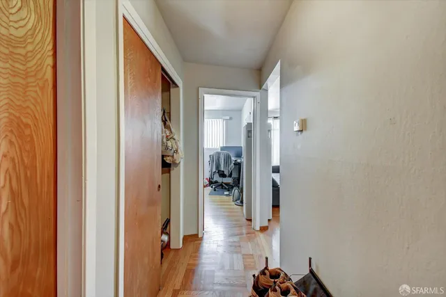 a view of a hallway with wooden floor and a livingroom