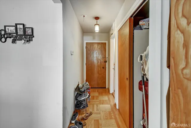 a view of a hallway with wooden floor and closet