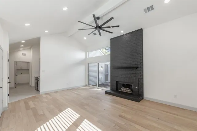 an empty room with a fireplace and wooden floor