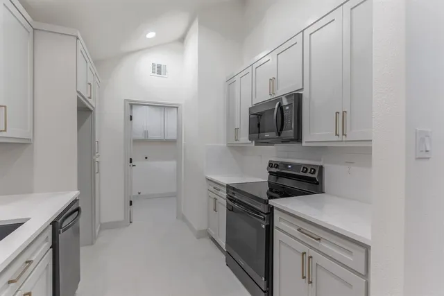 a kitchen with stainless steel appliances a sink stove and microwave