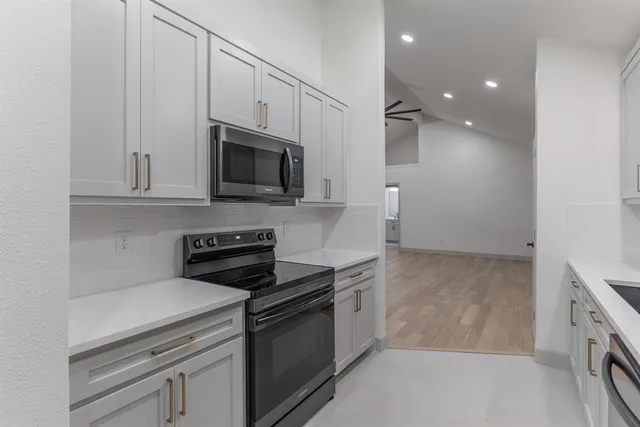 a kitchen with stainless steel appliances granite countertop a sink and a stove