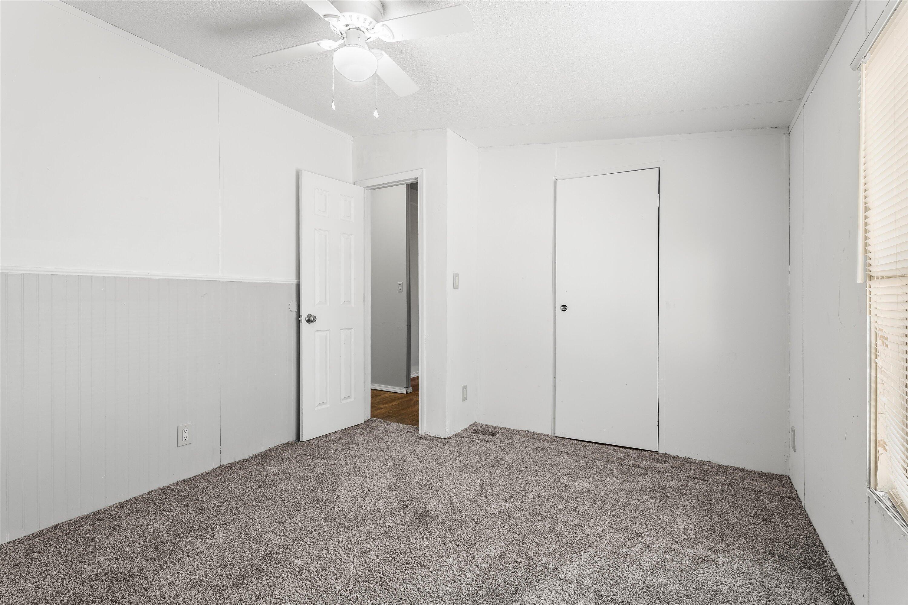9909 North Chester Avenue Lubbock, TX 79415 - Photo 20 of 24 an empty room with a ceiling fan and carpet