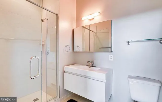 a bathroom with a toilet a sink and mirror
