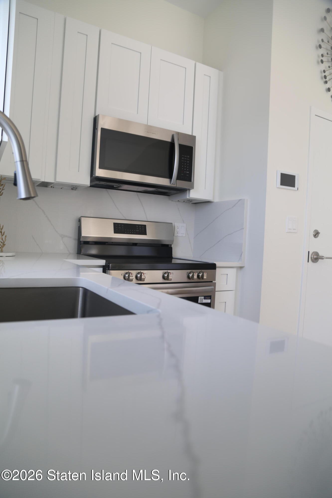 1221 Forest Hill Road, Unit 2 Staten Island, NY 10314 - Photo 3 of 10 a kitchen with stainless steel appliances a stove a microwave and a sink