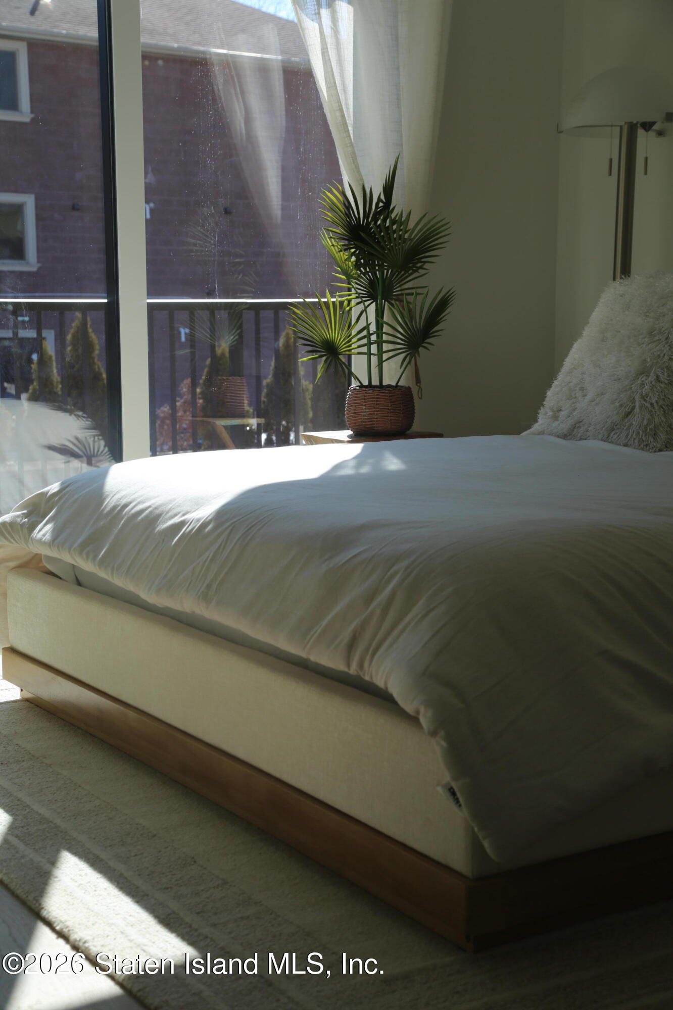 1221 Forest Hill Road, Unit 2 Staten Island, NY 10314 - Photo 6 of 10 a bed sitting in a bedroom next to a window