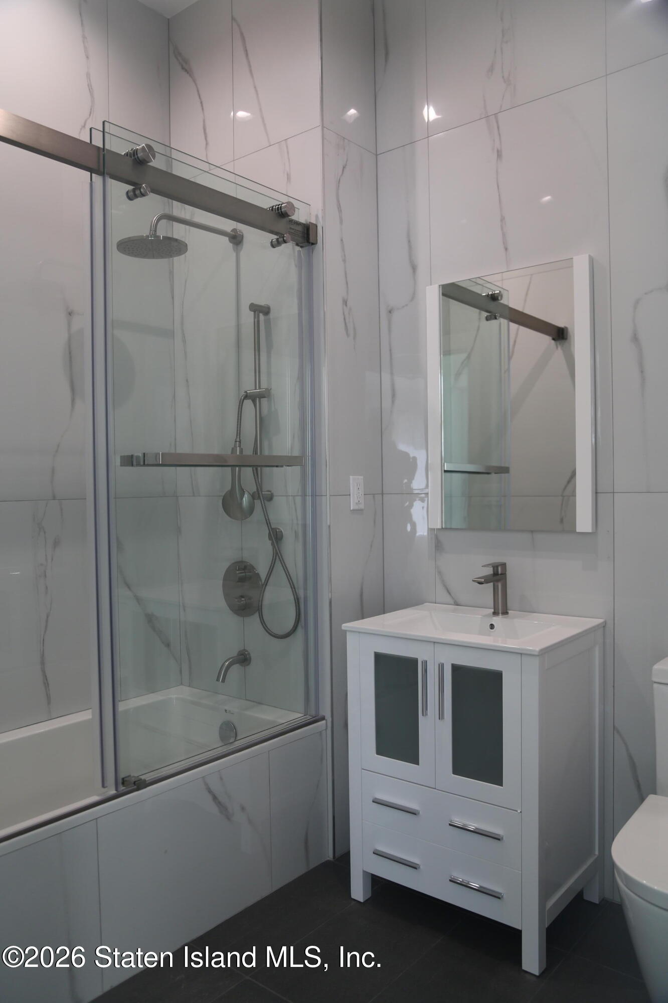 1221 Forest Hill Road, Unit 2 Staten Island, NY 10314 - Photo 7 of 10 a bathroom with a shower sink and mirror