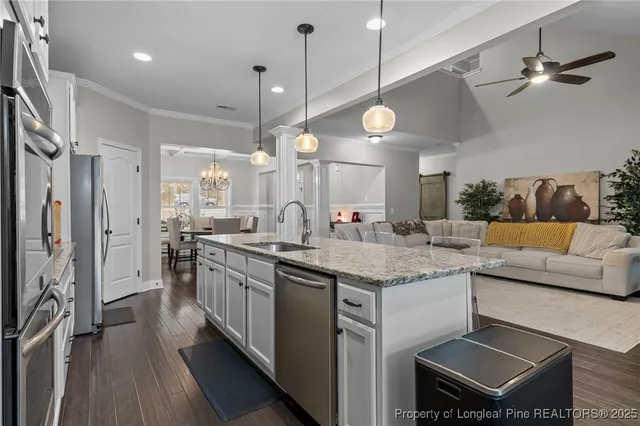a kitchen with kitchen island granite countertop a stove a sink and a microwave