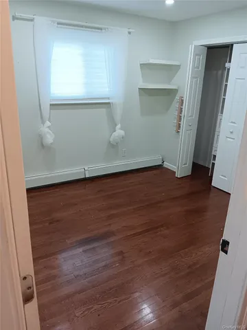 an empty room with wooden floor and closet