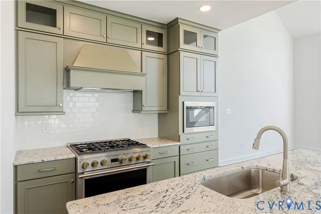 a kitchen with stainless steel appliances granite countertop a stove and a refrigerator