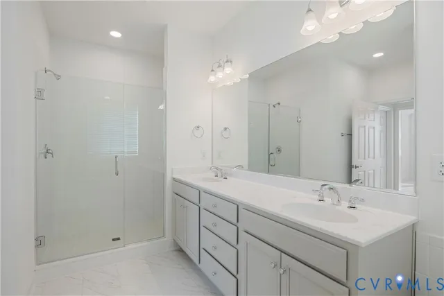 a bathroom with a double vanity sink mirror and shower