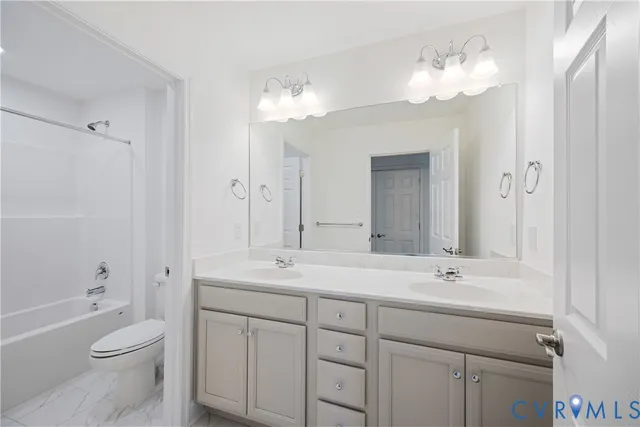 a bathroom with a double vanity sink mirror and toilet